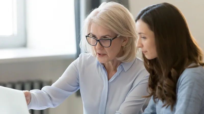 Genç bir kadına belgeler üzerinde rehberlik eden deneyimli mentor